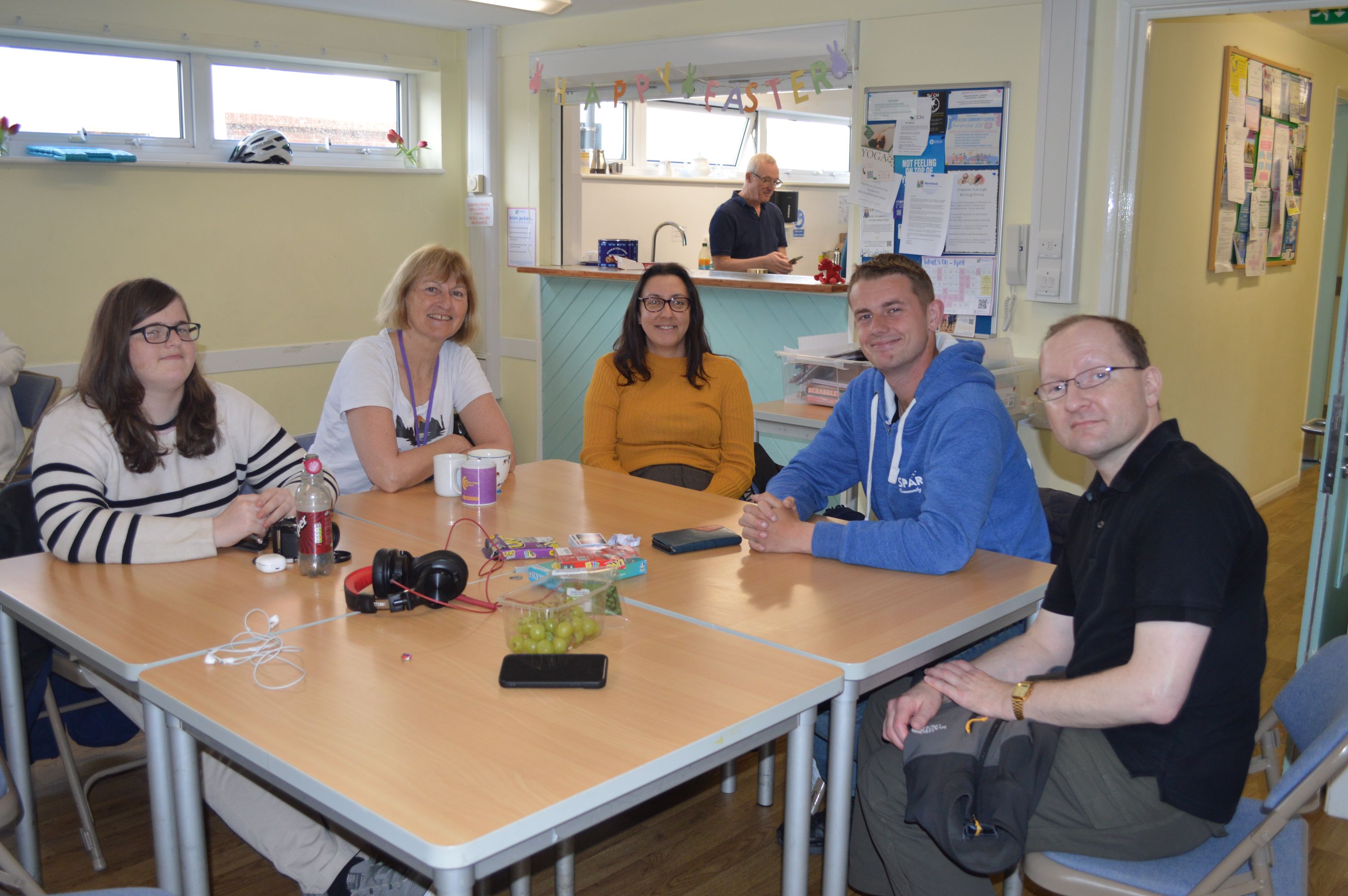 Portsmouth Serendipity group - members sit around a table smiling at the camera.
